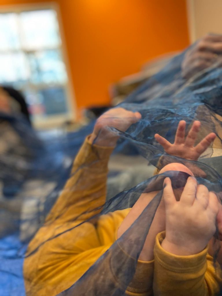 barnehender som leker med ett sjal