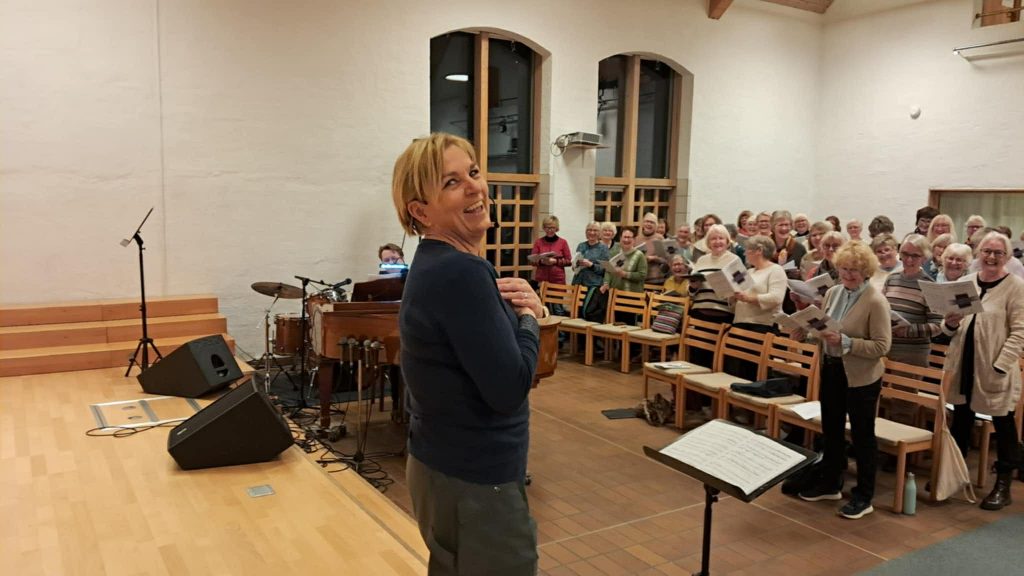 Bilde av Ingrid som smiler og foran en forsamling