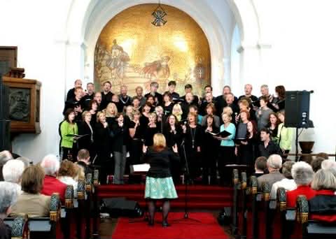 Ingrid som dirigerer ett kor i en kirke