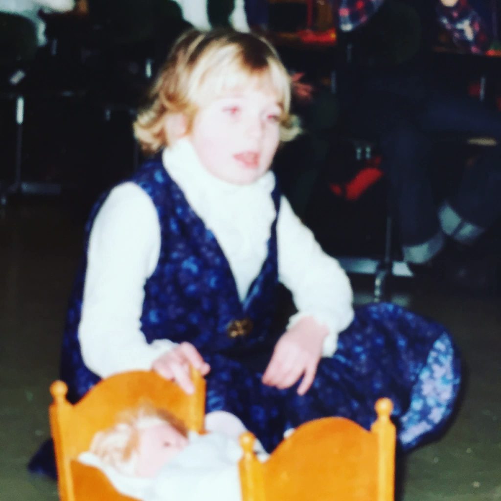 Bilde av Ingrid som barn, med en dukke